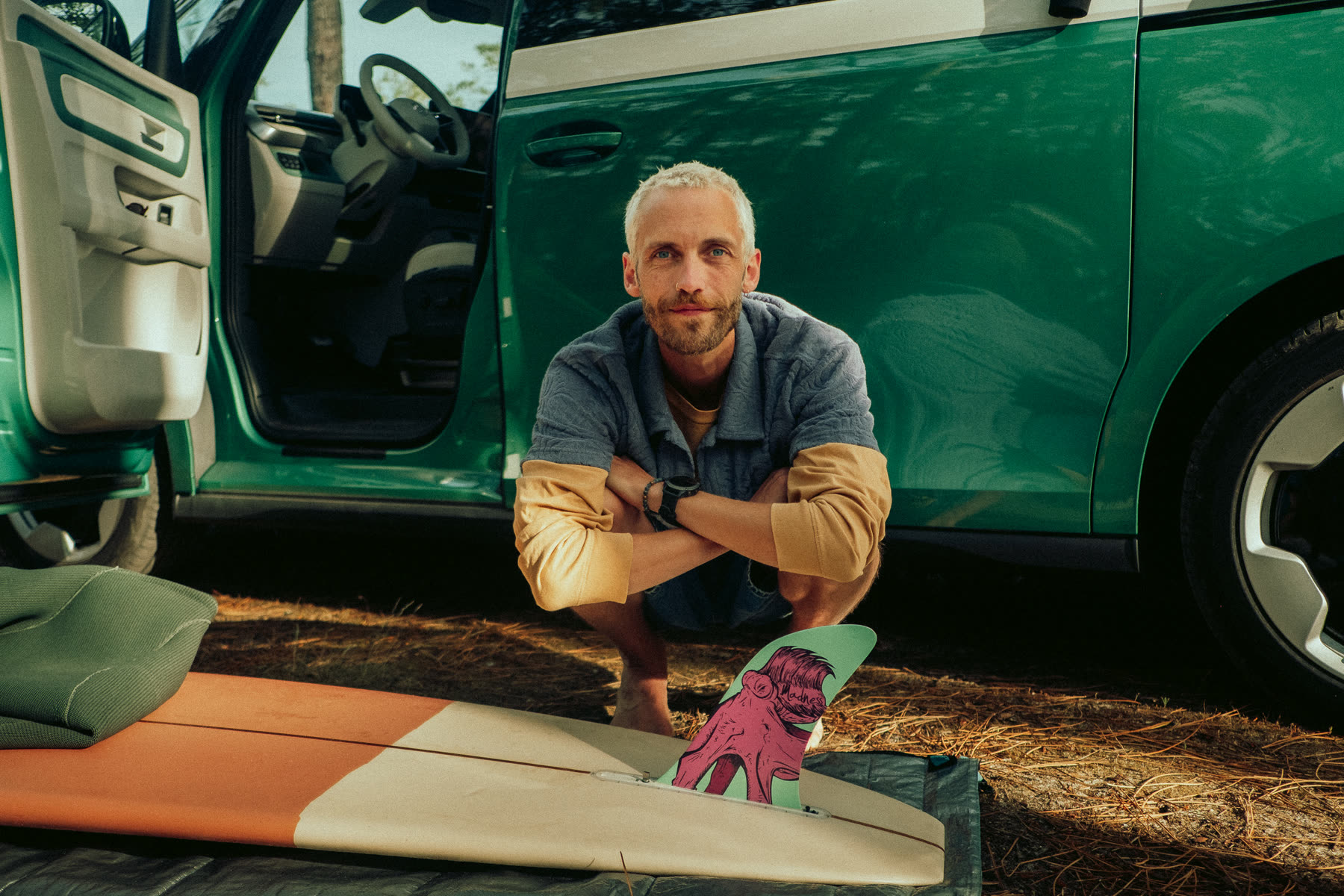 Phil Wildschütz mit Surfboard vor seinem Bus